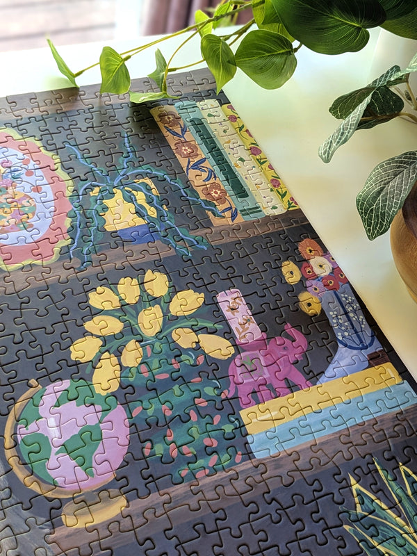 Jigsaw puzzle with colorful design on a table with plants in the background