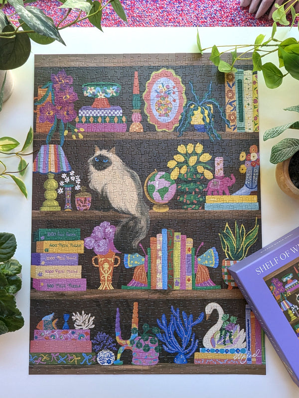 Jigsaw puzzle with a cat on a bookshelf design, surrounded by plants.