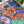 Colorful jigsaw puzzle artwork of a woman with cats and abstract patterns on a desk surrounded by plants