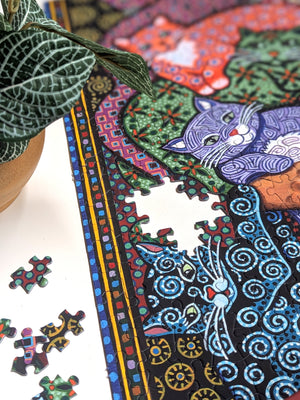Colorful puzzle with cat design and scattered pieces on a white surface