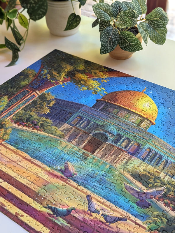 Jigsaw puzzle with a completed section featuring a colorful architectural scene, surrounded by potted plants.