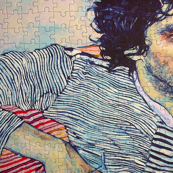 A close up of the jigsaw puzzle 'Serious Snack' showing a small portion of a mans head who is wearing a black and white striped shirt. 