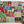 A holiday jigsaw puzzle featuring Christmas-themed blocks with the words JOY, PEACE, NOEL, and JOLLY, plus ornaments, Santa, trees, candy canes, snowflakes, and holiday motifs. Pine branches frame the top and bottom corners against a white surface.