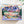 Top view of puzzle box showing illustration of beautiful mountain and valley scene. Box is on white background surrounded by small foliage.