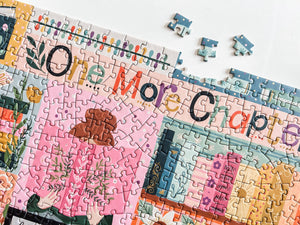 Jigsaw puzzle with colorful pieces featuring a book design, with text 'One More Chapter'.