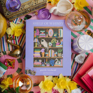 Shelf of Whimsy puzzle box surrounded by decorative items on a colorful background