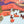 A partially completed landscape jigsaw puzzle with loose pieces scattered on a light surface, including a small stone prop.
