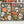 An art print featuring a colorful Halloween design with sugar skulls, jack-o'-lanterns, candelabras, and butterflies on a black background, displayed on a white surface with a partial view of a completed puzzle featuring the same art.