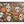 A completed jigsaw puzzle featuring a colorful Halloween collage with sugar skulls, jack-o'-lanterns, butterflies, leaves, candles, and spiders on a dark background, photographed against a plain white backdrop.