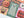 Partial view of a completed Halloween-themed jigsaw puzzle centered on the artwork of a floral designed ghost on muted green background with stars, also visible are a pumpkin, candy corn, eyeball and living flowers with sharp teeth. 