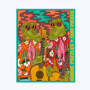 Jigsaw puzzle box against a white surface. Box shows illustration of two Alligator men wearing fun shirts with floral details holding guitars. 