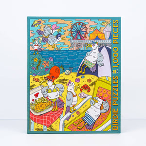 Colorful puzzle box with cartoon birds wearing bathing suits eating french fries and a beach scene on a white background
