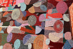 Close up of puzzle details showing colorful abstract artwork of logs created with circular patterns and vibrant colors