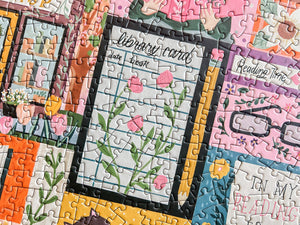 Close-up of a puzzle with colorful pieces featuring library card and other book-themed illustrations.
