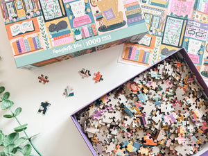 Puzzle with pieces spilling out of a box on a white surface