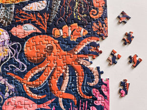 Jigsaw puzzle with an underwater scene featuring an octopus, partially completed on a light gray background.